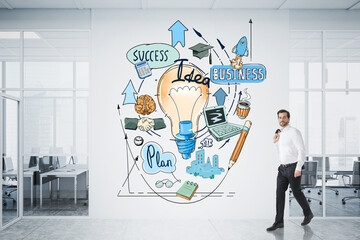 Businessman in white shirt holding his jacket on shoulder and walking throughout the wall with business development sketch, office in downtown with panoramic windows. Brainstorm concept.