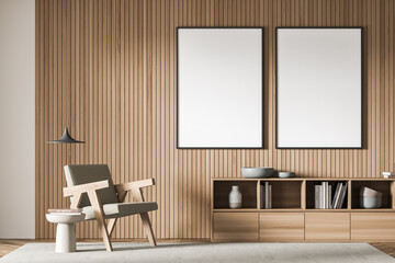 Two posters on the wall lining, pendant lamp and beige armchair