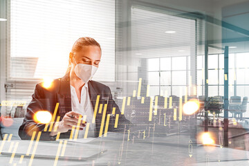 Attractive business woman in suit and face protective masks in office space working with financial report, forex hologram on foreground, double exposure.