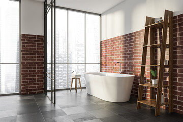 Corner of panoramic bathroom with brick alike walls and white tub