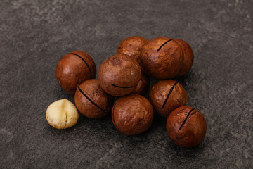 Brown macadamia nut heap over background