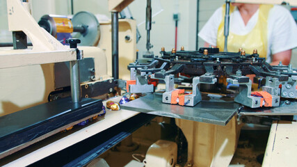 Candy factory. Industrial machine wrapping candies. Modern industrial machine wrapping tasty sweets and putting them on conveyor on confectionery factory.