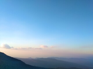 High altitude view with intricate green mountains and orange blue sky on vacation.