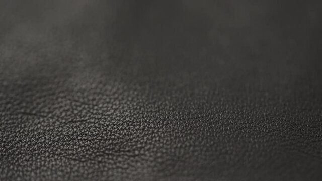 Slow motion closeup slide shot of soft gray brown leather
