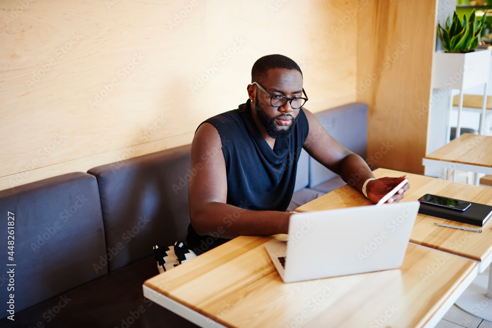 Poster millennial male blogger touch pad using laptop technology for browsing web publication while network