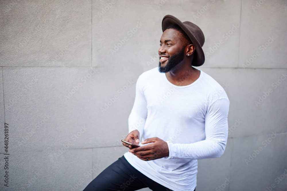 Poster side view of happy black model in trendy hat and blank clothes with copy space area for label name s
