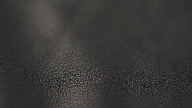 Slow motion closeup slide shot of soft gray brown leather