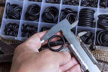 Measuring the diameter of the rubber ring with a caliper. A man is holding an old measuring...