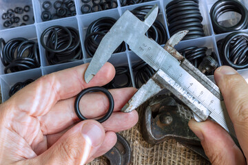 Measuring the diameter of the rubber ring with a caliper. A man is holding an old measuring...