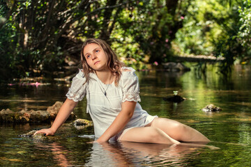 woman with white dress near stream of water