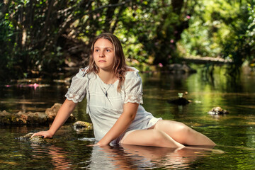 woman with white dress near stream of water