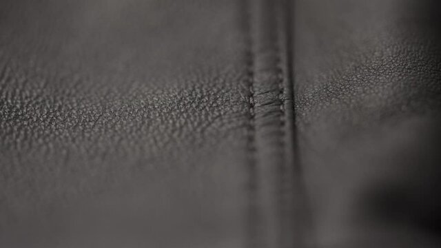 Slow motion closeup slide shot of soft gray brown leather