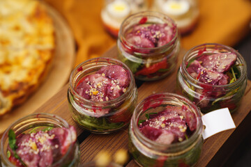 serving salads in portions in small glass jars. buffet for the holiday. 
