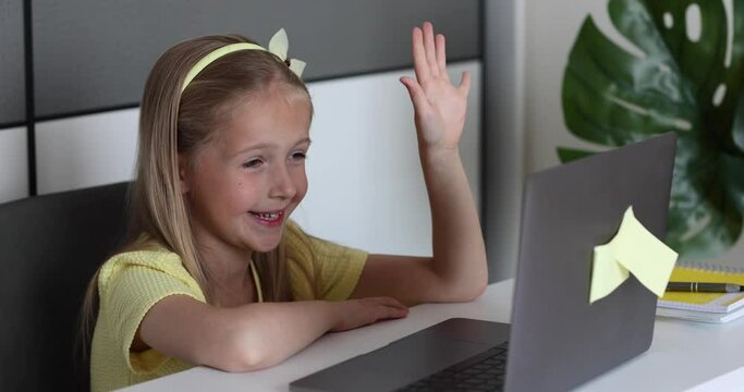 Caucasian little girl school pupil studying online from home, watching web class lesson or listening tutor by video call elearning during coronavirus covid-19 pandemic self isolation. Slow motion