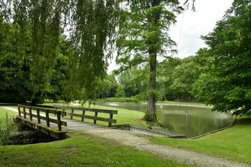 Petit pont en bois enjambant un des bras étroits de l'étang principal du parc des Trois Fontaines à Vilvoorde