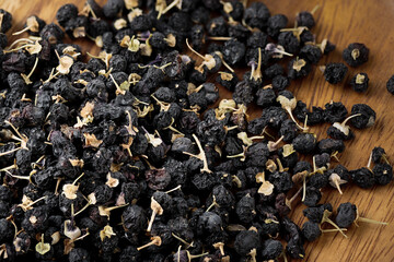 Black goji berry or black wolfberry on wodden dish.