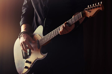 Obraz na płótnie Canvas Man playing electric guitar on stage, closeup. Rock music