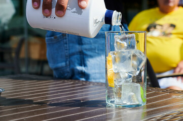 Detail of  barkeeper serving a gin tonic in a terrace