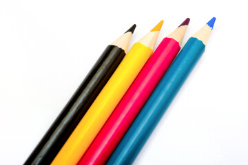 Four colored pencils. The colors cyan, magenta, yellow and black. The concept of polygraphy.