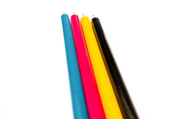 Four colored pencils. The colors cyan, magenta, yellow and black. The concept of polygraphy.