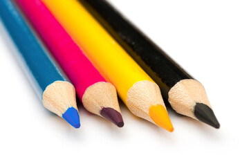 Four colored pencils. The colors cyan, magenta, yellow and black. The concept of polygraphy.