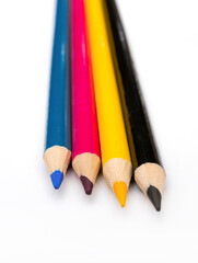Four colored pencils. The colors cyan, magenta, yellow and black. The concept of polygraphy.