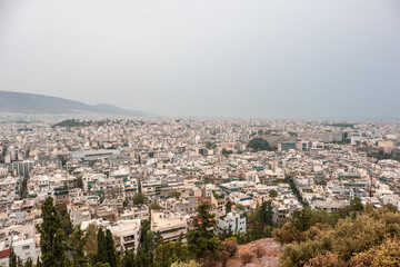 Fototapeta na wymiar Modern Athens city center streets with white buildings on cloudy foggy day. Rooftop Attica view from Filopappou Hill near Acropolis, Greece