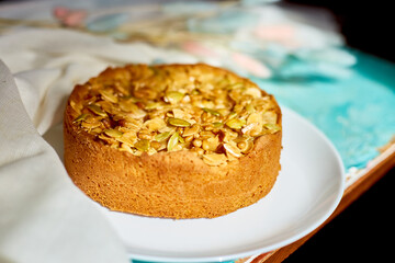 Apple or pear pie, tart with caramel nuts on blue table with sunlight