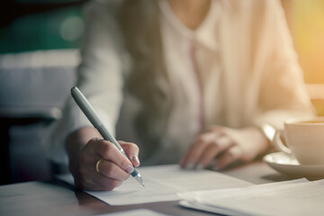 hand of a business woman writing on paper in the office