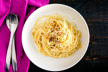 Bowl of Angel Hair Pasta with Roasted Garlic and Parmesan: Angel hair pasta noodles with roasted garlic, parmesan cheese, lemon zest, and red pepper flakes