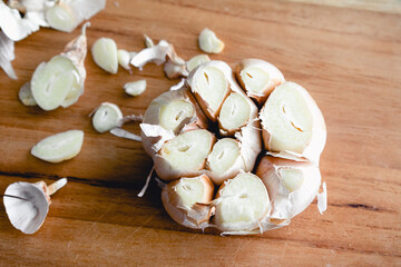 Trimmed Head of Garlic on a Bamboo Cutting Board: A head of garlic that has had the ends trimmed off for roasting