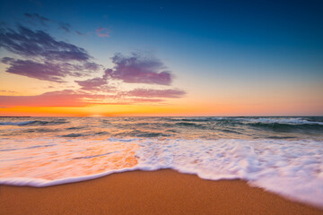 Naklejka na ściany i meble Beautiful sunrise over the sea and beach