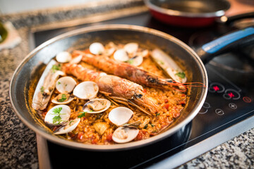 Close-up of freshly made homemade paella. Rice with prawns and clams.