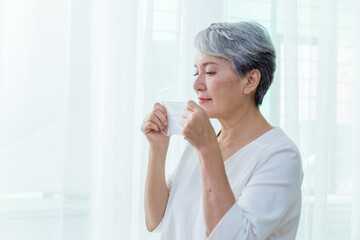 Asian senior woman suffer from cough with face mask protection