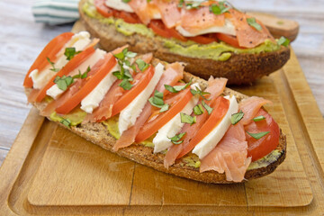 tartine de pain au saumon fumé, guacamole, mozzarella et tomate