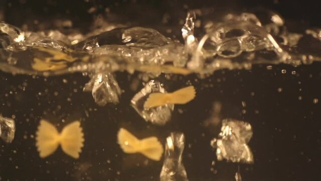 pasta falling into boiling water