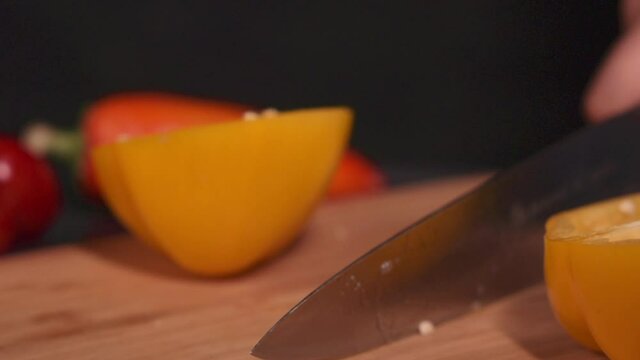 Slow motion picture of a cook cutting a pepper
