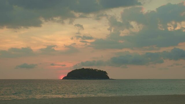 time lapse the yellow sun going down to the sea..beautiful moving cloud in golden sky at sunset in Kata beach Phuket Thailand.4k stock footage video in travel concept.