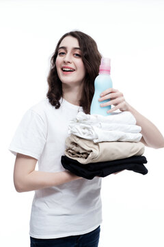 Isolated On White Portrait Of Smiling Woman Holding Clothes And Laundry Detergent .