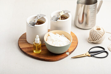 Ingredients and tools for handmade aroma candles. Organic soy wax, essential oils, wicks, pots. Craft hobby, small business, artisan products concept