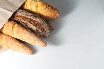 Bread baguettes in a paper bag on a white background. Horizontal orientation .Copy Space.