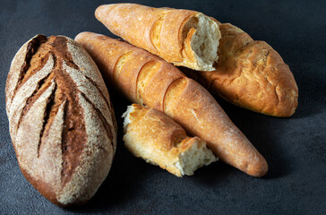 Bread loaves on a dark background. Horizontal orientation, close-up.