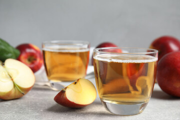 Delicious cider and ripe apples on grey table. Space for text