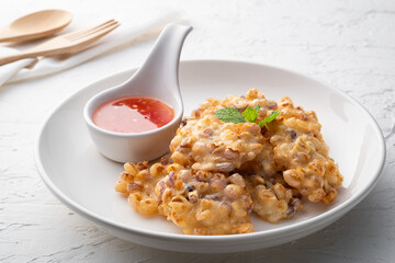 Deep fried Corn cake (Sweet Corn Fritters) on white plate with Chili sauce