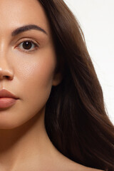 Fototapeta premium Half beauty portriet woman smiling at the camera with a snow-white smooth. Beautiful natural makeup, puffy lips, smooth and thick eyebrows, extremely long eyelashes. Clean fresh skin