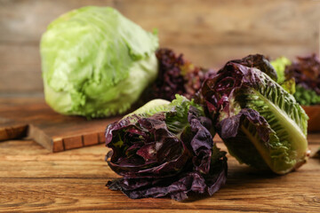 Red romaine lettuce on wooden table, space for text