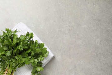 Bunch of fresh aromatic cilantro on grey table, top view. Space for text