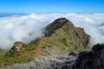 Fototapeta na wymiar Pico Ruivo mountain landscape in the clouds, hiking part along lonely house, Madeira, Portugal, Europe