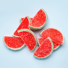 Jelly candies. Top view of watermelon jelly candies sprinkled with sugar on a blue background. Watermelon marmalade. Selective soft focus.