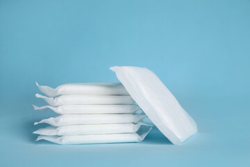 Stack of menstrual pads on light blue background